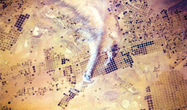 These large circular fields in the Saudi Arabian desert are a testament to the failed food self-sufficiency programme in the 1970s and 1980s. Its unsustainability has forced Saudi Arabia to wind down production in areas such as wheat and end production by 2016. Seen here are the once-green lands slowly being reclaimed by the desert. (Image Corbis).